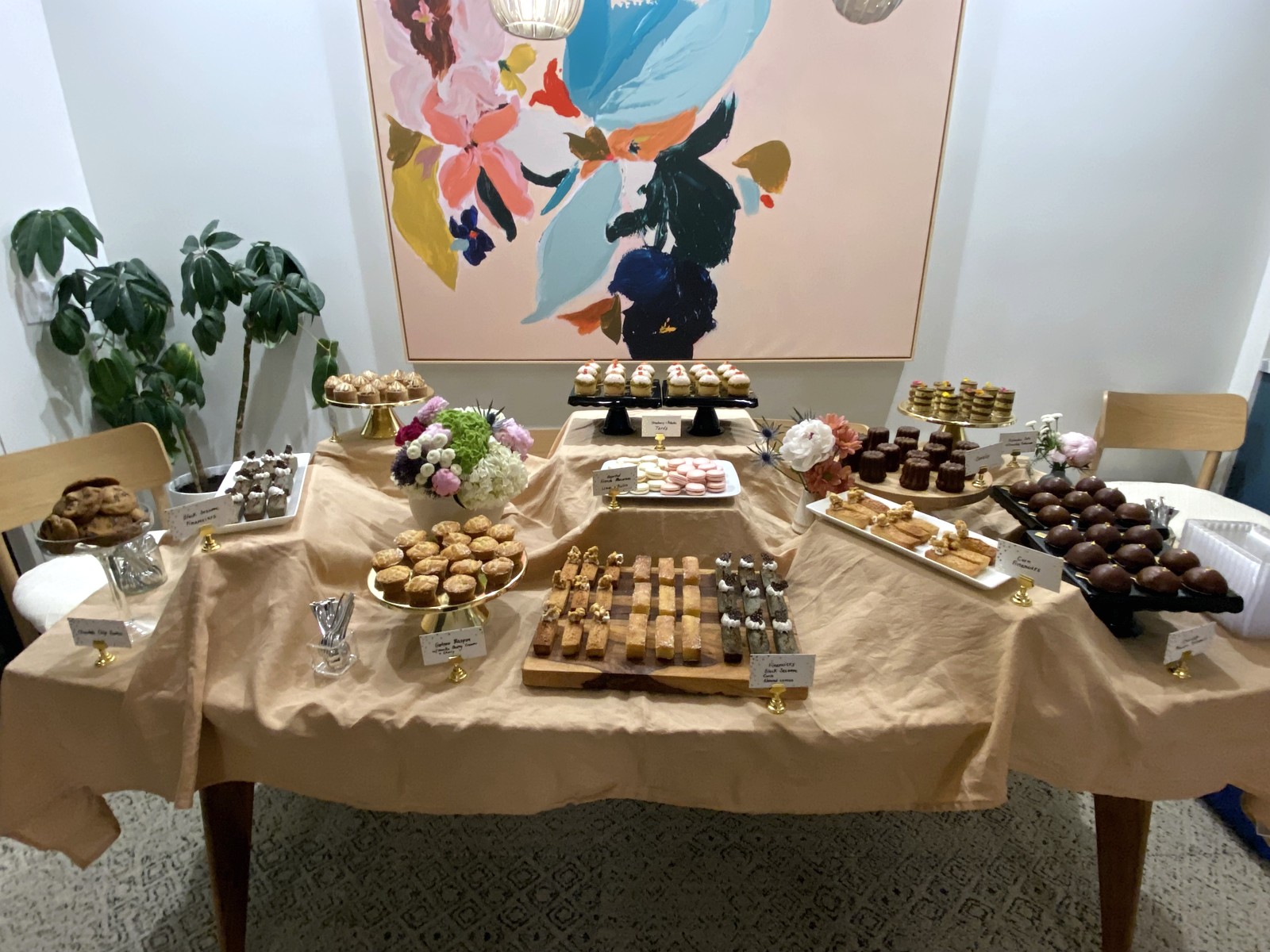Wedding dessert table with assorted small bites and floral arrangements