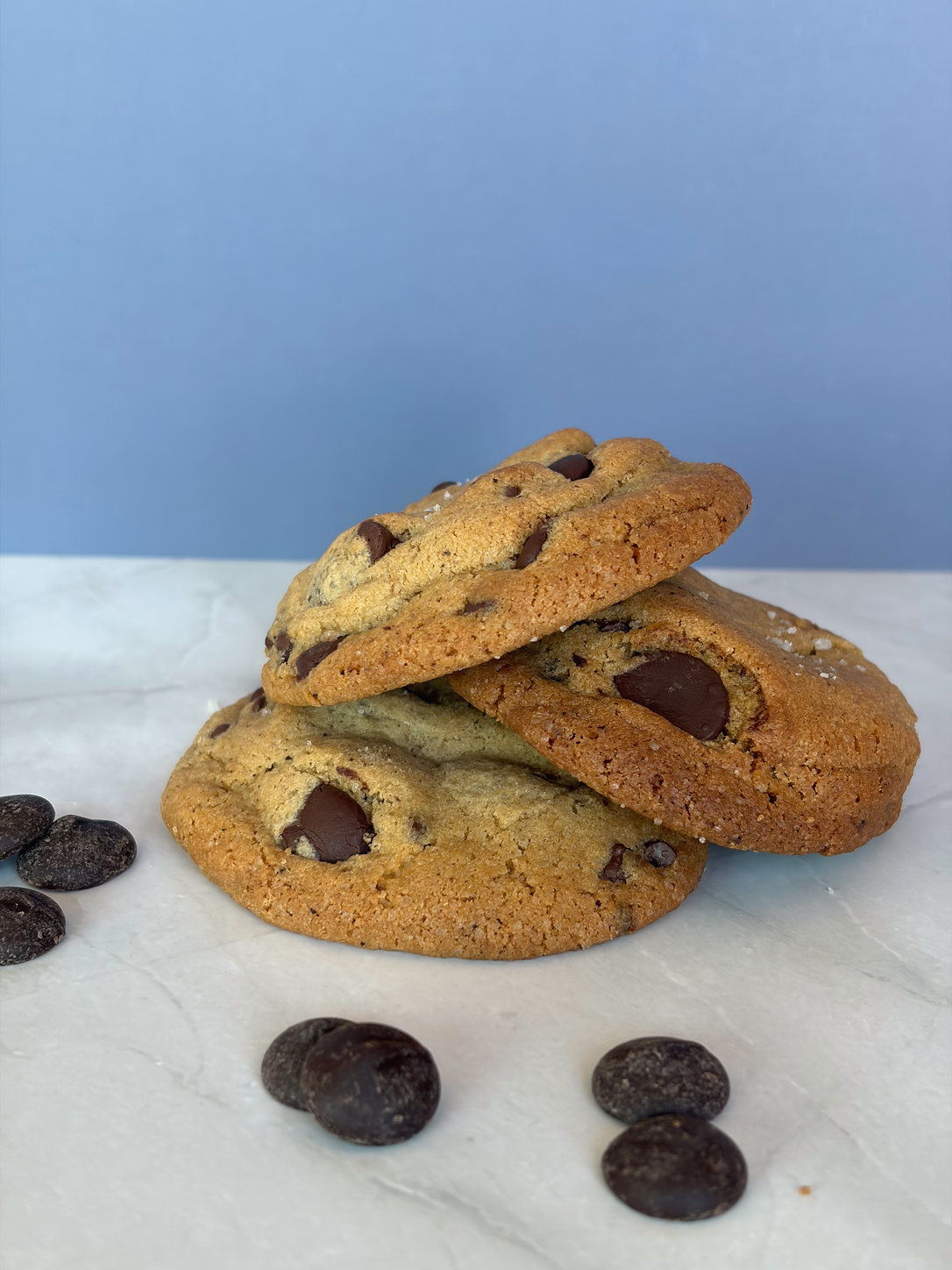 Stack of chocolate chip cookies with dark chocolate pieces and flaky salt